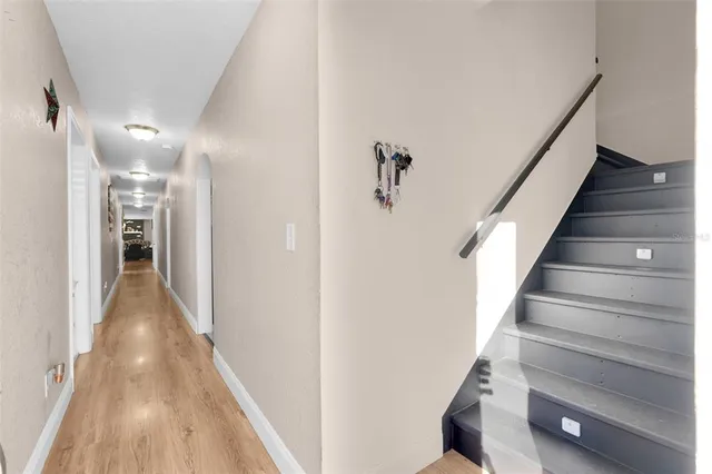 a view of a hallway with wooden floor and staircase