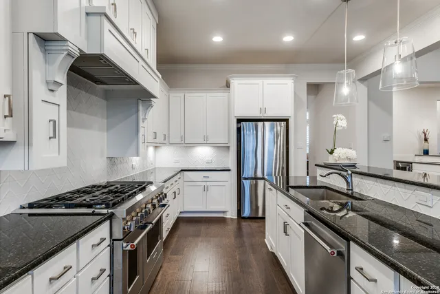 a kitchen with stainless steel appliances a sink stove and refrigerator