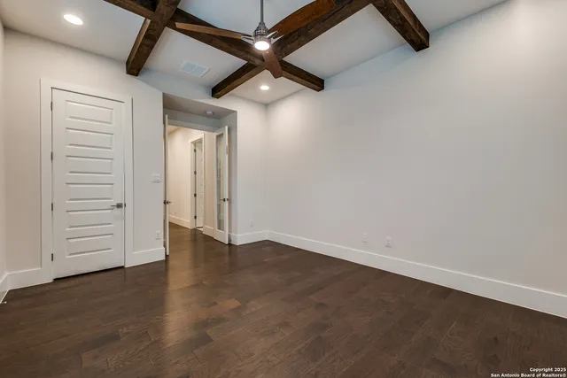 an empty room with hard wood floors and window