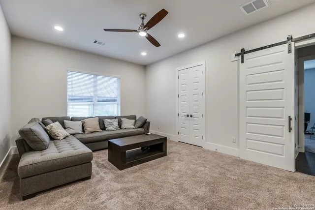 a living room with furniture and a ceiling fan