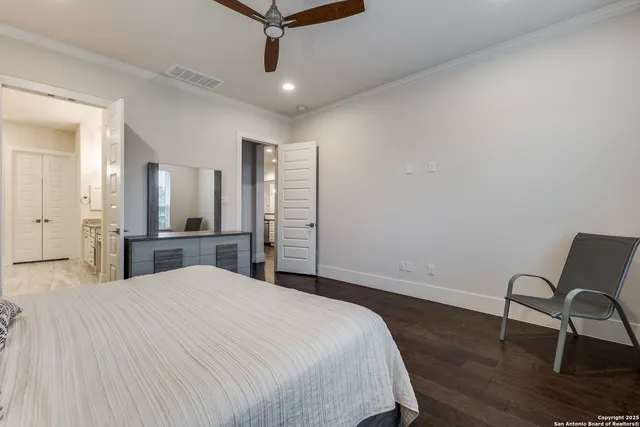 a large bedroom with wooden floor and a sink