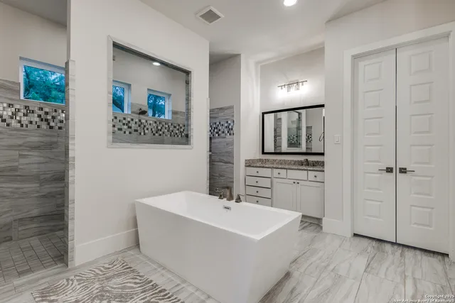 a bathroom with a bathtub a sink and a mirror