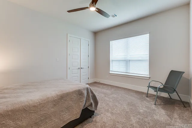a spacious bedroom with a bed and chair