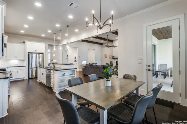 a kitchen with refrigerator a sink and chairs