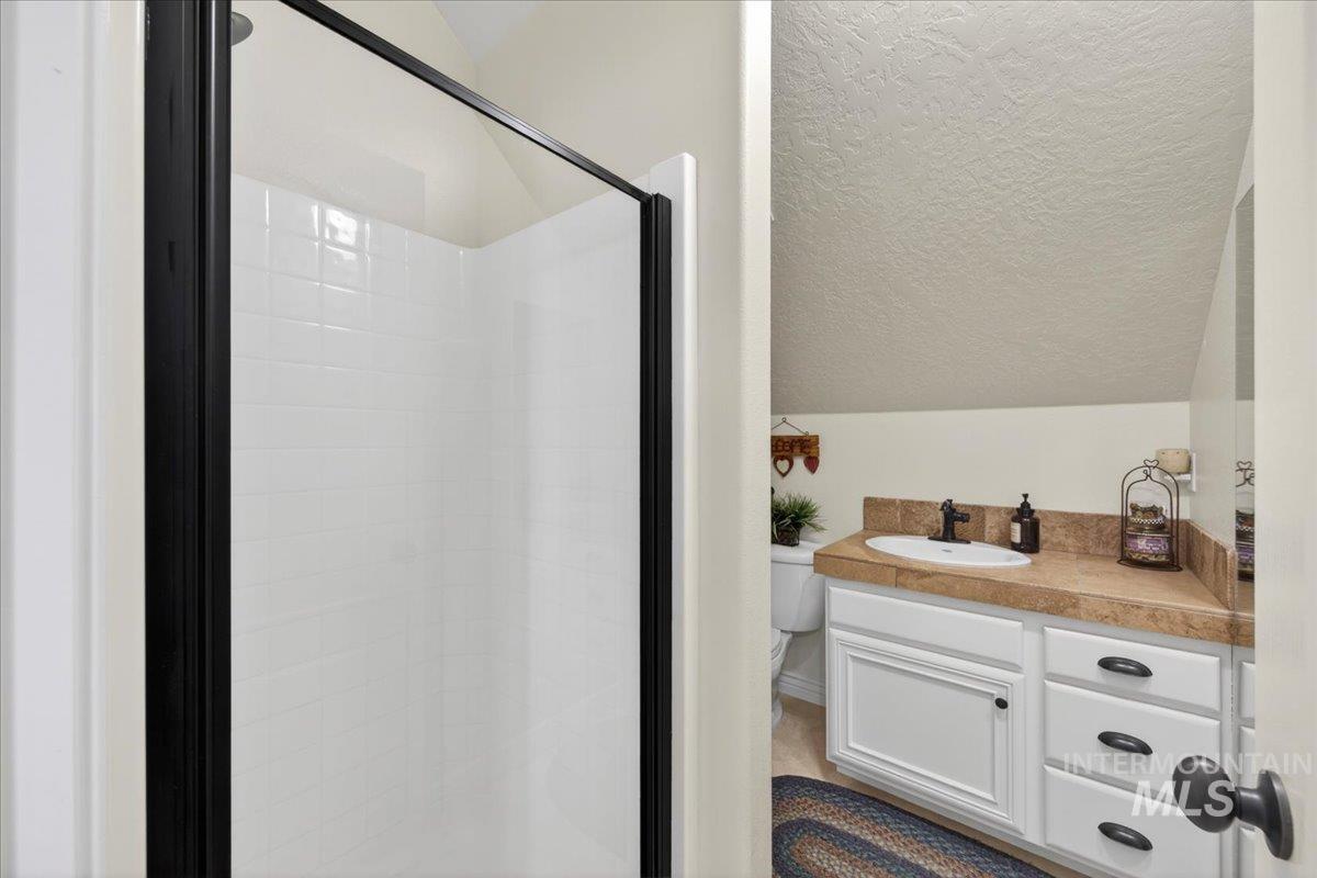 414 East Shafer View Drive Meridian, ID 83642 - Photo 33 of 50 Bonus room bathroom is in immaculate condition and has a Fiberglass shower with glass door, tiled vanity w/backsplash, sink and toilet