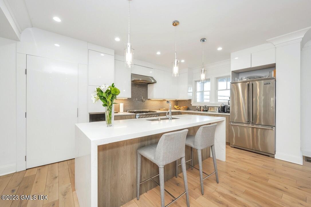 1 Home Place, Unit A Greenwich, CT 06830 - Photo 7 of 22 a kitchen with kitchen island white cabinets and refrigerator