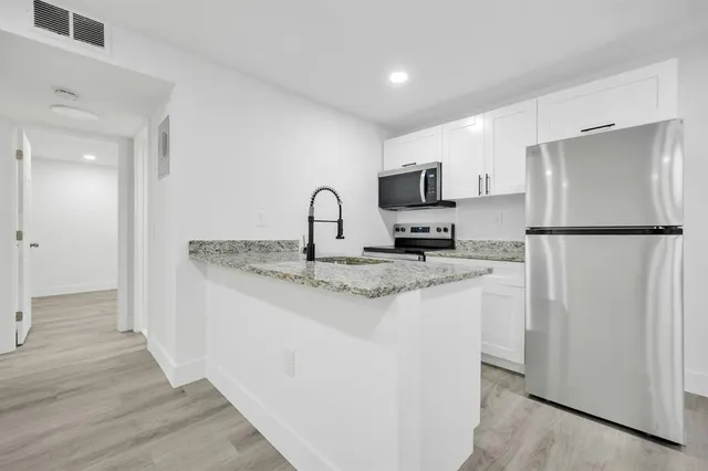 a kitchen with stainless steel appliances granite countertop a refrigerator sink and stove