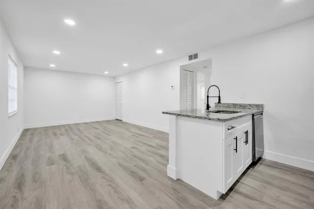 a kitchen with a sink cabinets and wooden floor