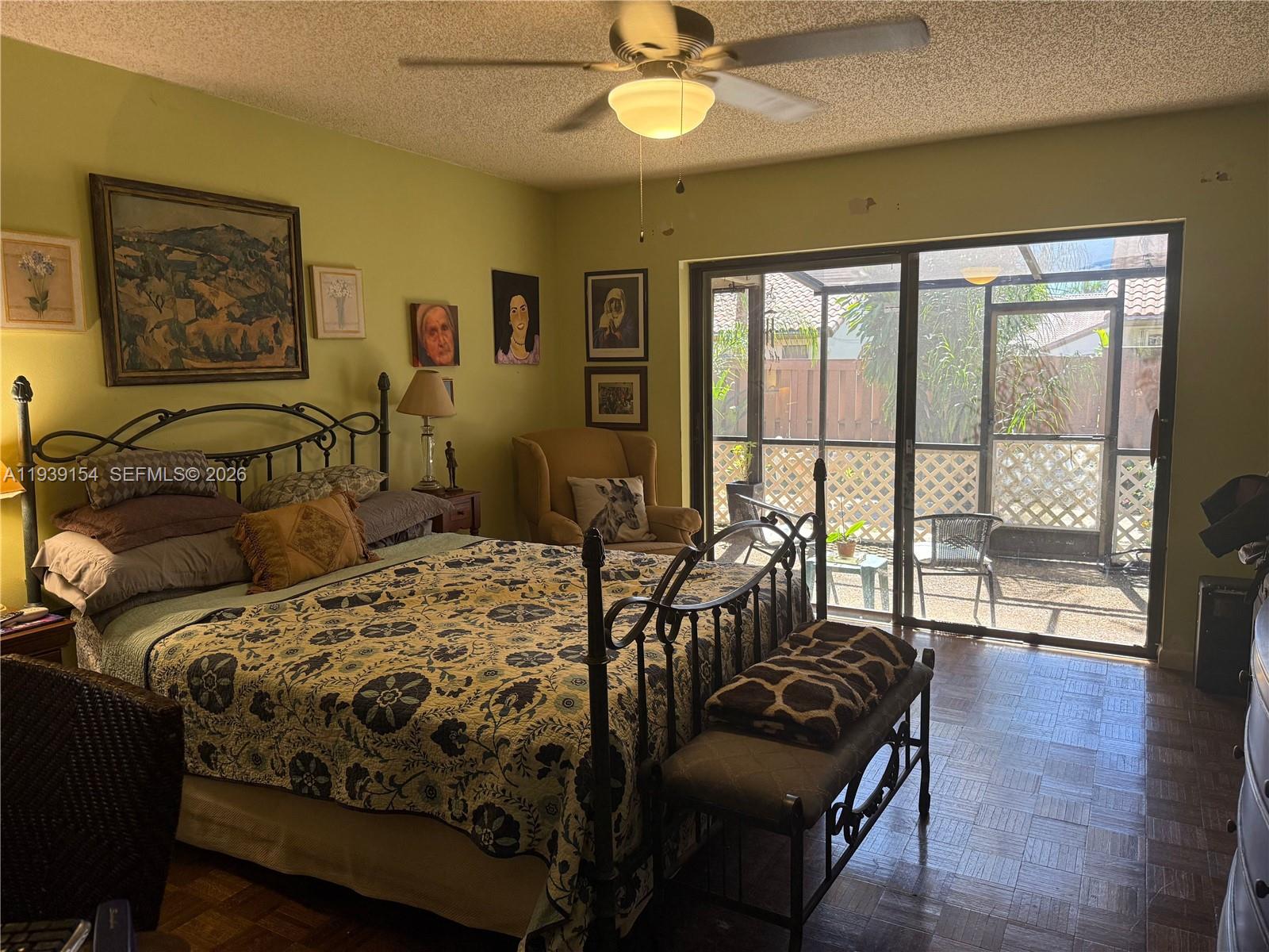 11438 Southwest 86th Lane Miami, FL 33173 - Photo 12 of 17 a bedroom with a bed a couch and a large window with wooden floor