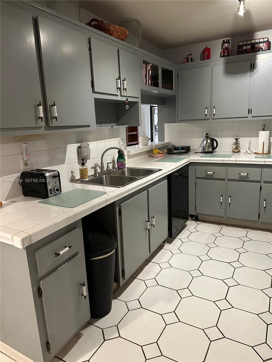 11438 Southwest 86th Lane Miami, FL 33173 - Photo 9 of 17 a kitchen with a sink a stove and cabinets