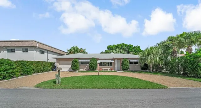 a front view of a house with a yard and potted plants
