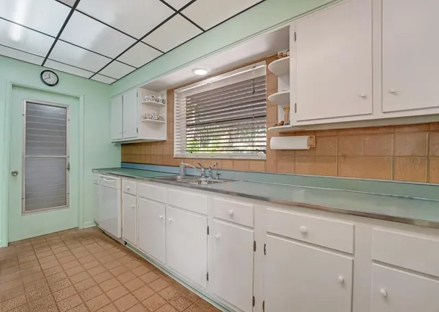 a kitchen with granite countertop white cabinets and a sink