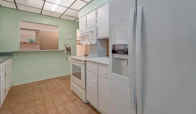a kitchen with white cabinets and white appliances
