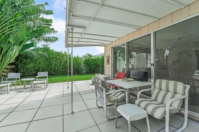 a view of a patio with a table chairs and a backyard