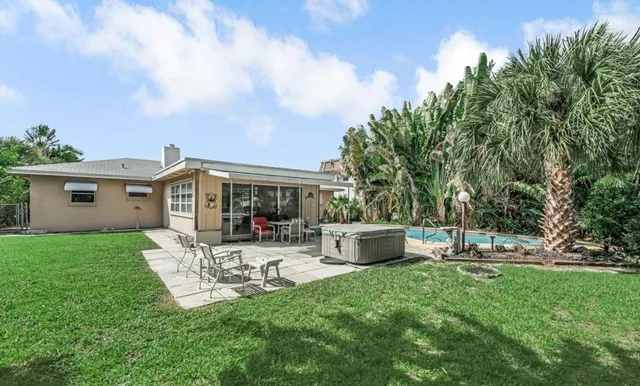 a view of a house with backyard sitting area and garden