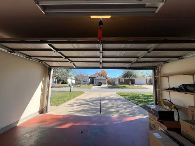 a view of an empty room with a fireplace and a chandelier fan