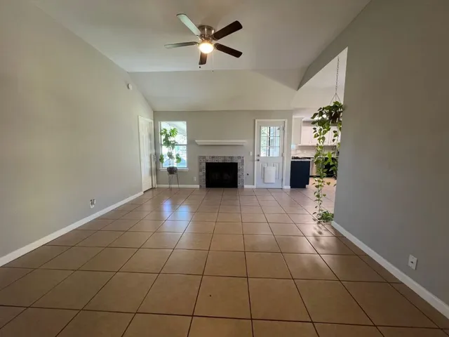 a view of a livingroom with a chandelier fan and fire place