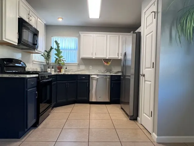a kitchen with granite countertop wooden cabinets and a stainless steel appliances