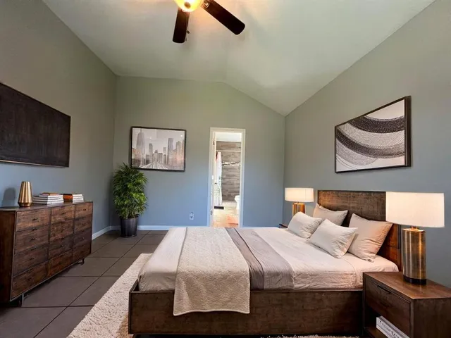 an empty room with windows and chandelier fan