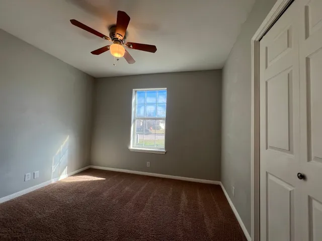 an empty room with a ceiling fan and a fan