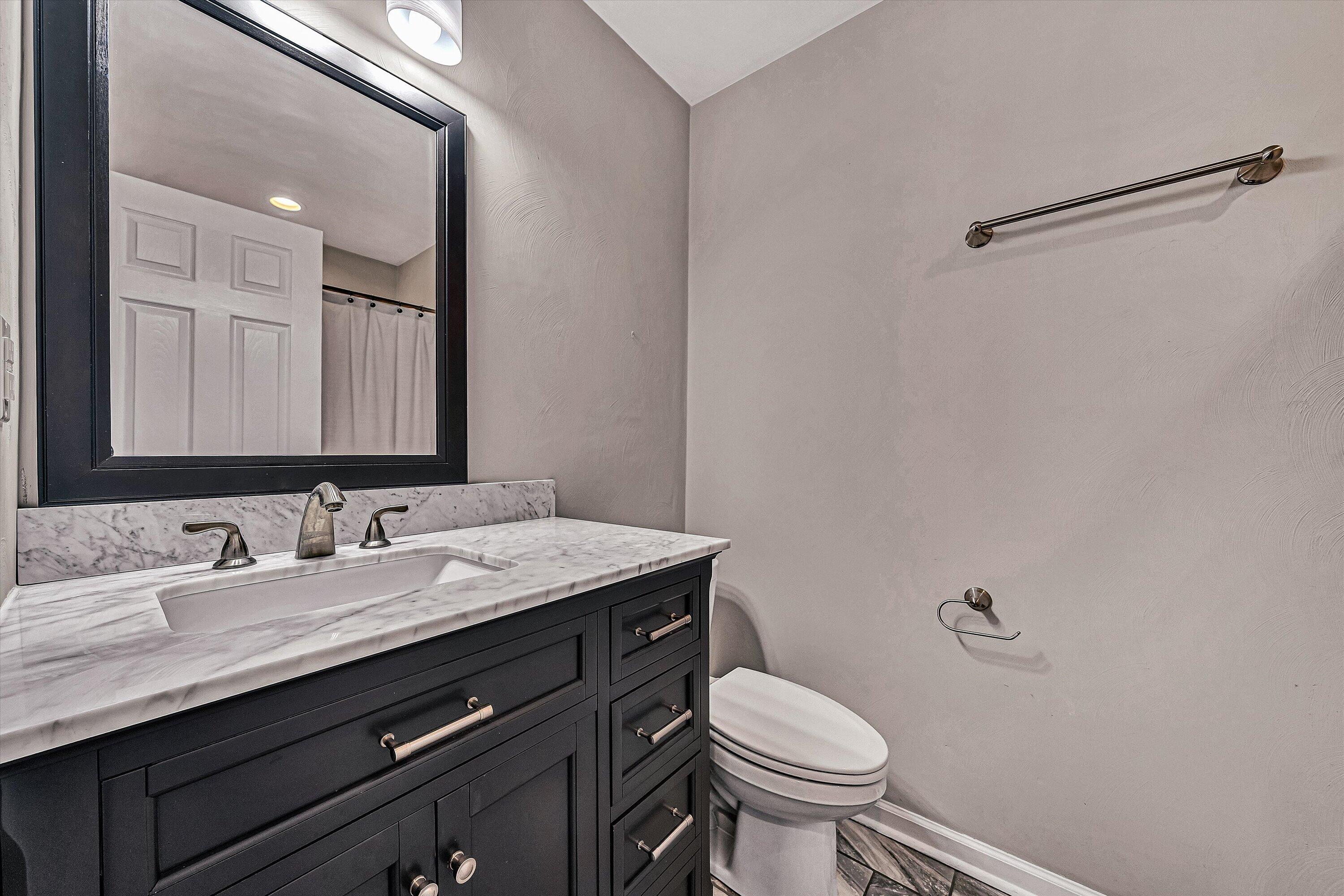2111 Woodland Road Southeast Roanoke, VA 24014 - Photo 17 of 31 a bathroom with a granite countertop toilet sink and mirror