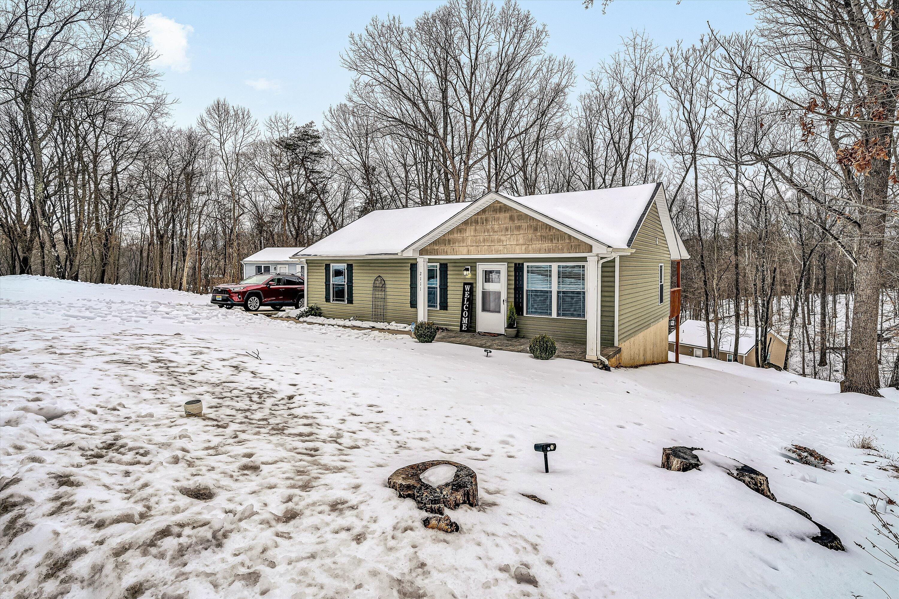 2111 Woodland Road Southeast Roanoke, VA 24014 - Photo 2 of 31 a view of a house with a yard covered in snow