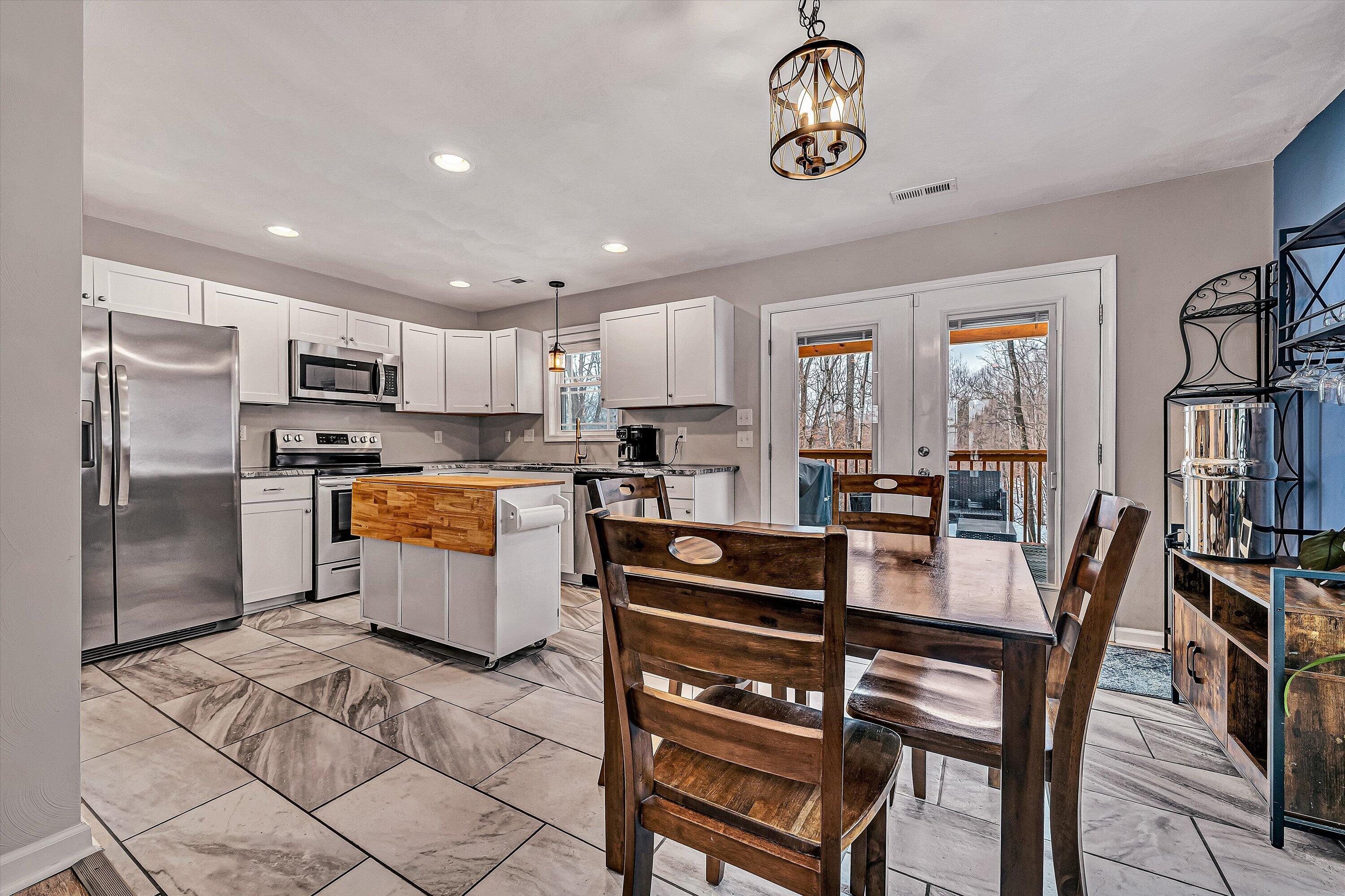 2111 Woodland Road Southeast Roanoke, VA 24014 - Photo 7 of 31 a kitchen with granite countertop a table chairs microwave and cabinets