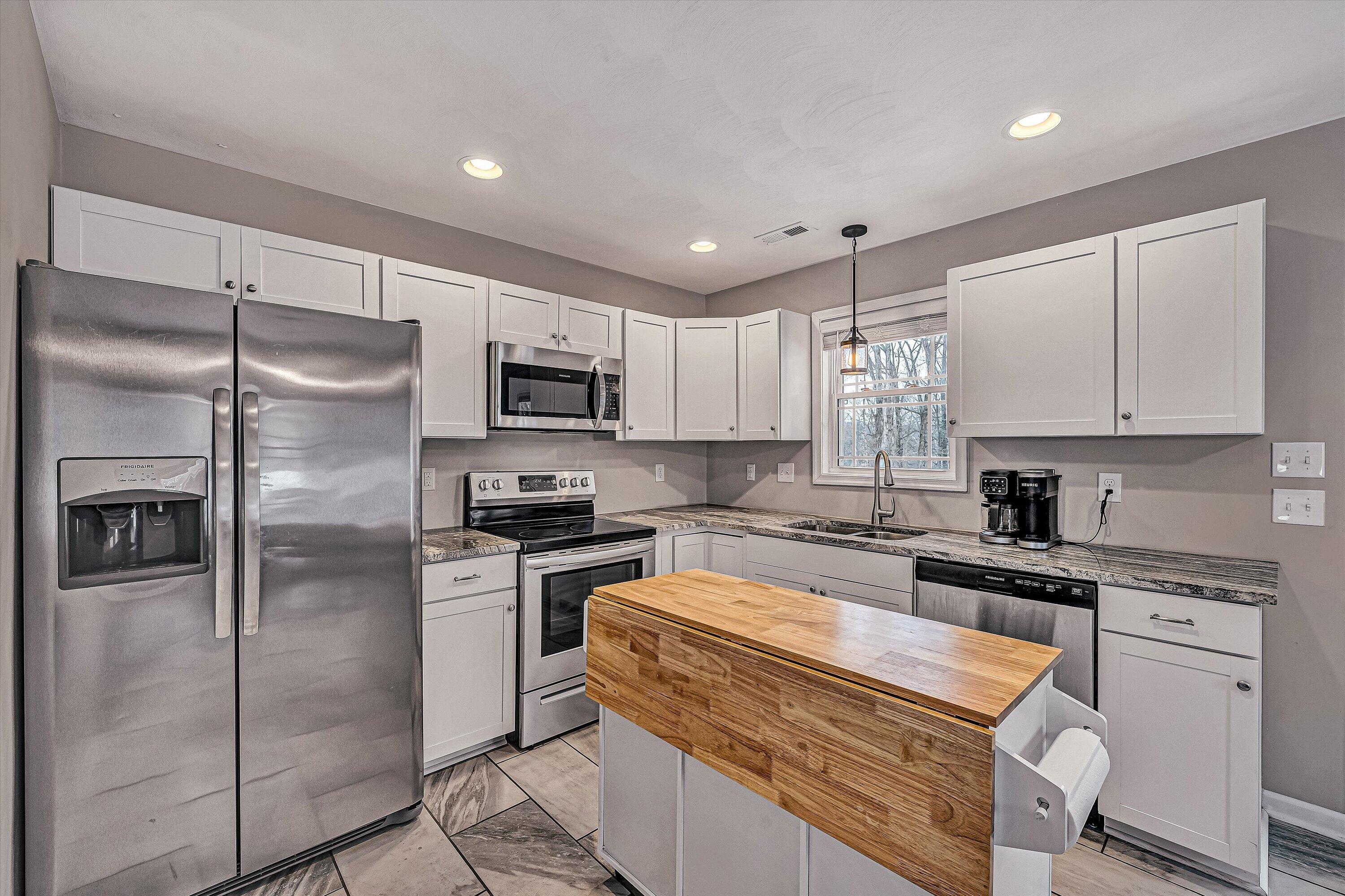 2111 Woodland Road Southeast Roanoke, VA 24014 - Photo 8 of 31 a kitchen with white cabinets stainless steel appliances and a window