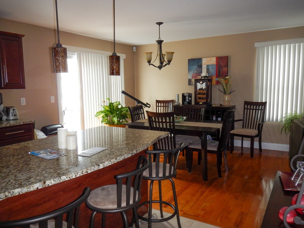 423 Detroit Street Fall River, MA 02721 - Photo 6 of 12 a kitchen with stainless steel appliances granite countertop a dining table chairs and chandelier