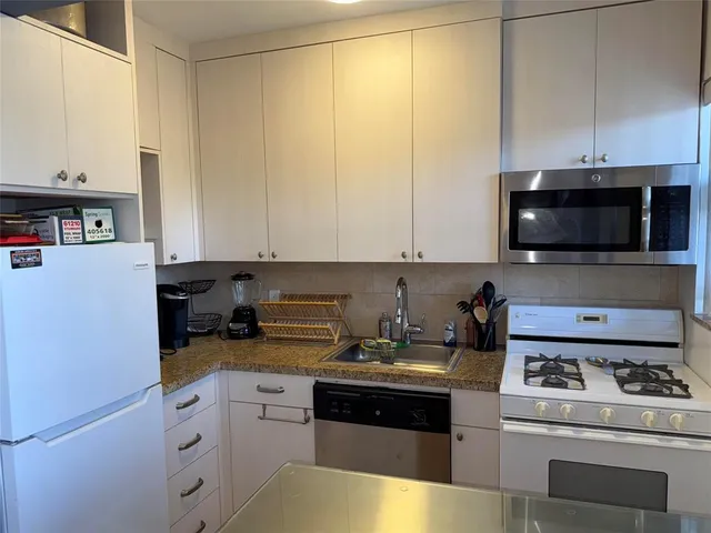 a kitchen with a sink a stove and cabinets