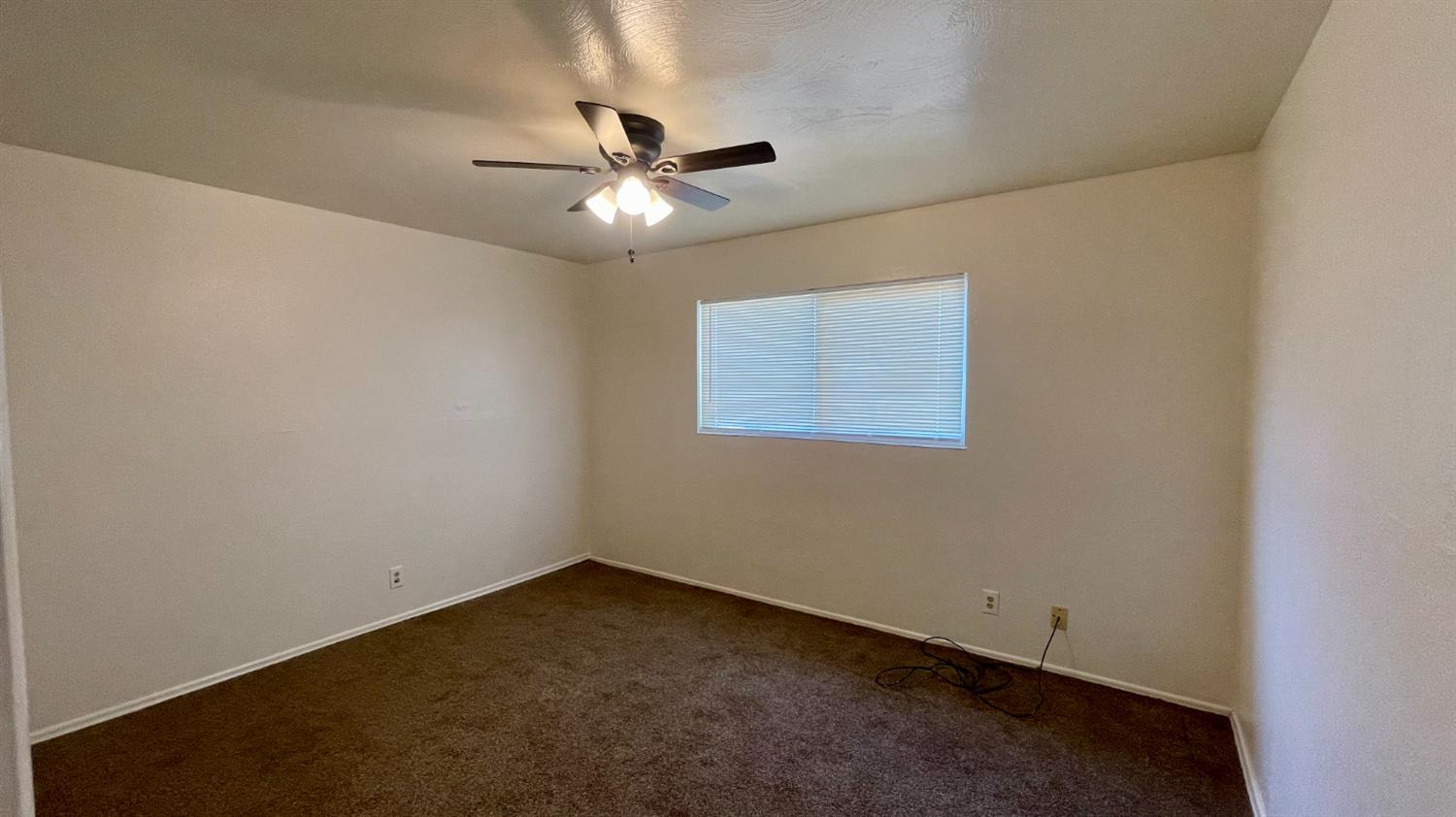 1412 Rodgers Road Hanford, CA 93230 - Photo 7 of 9 an empty room with a window and a fan