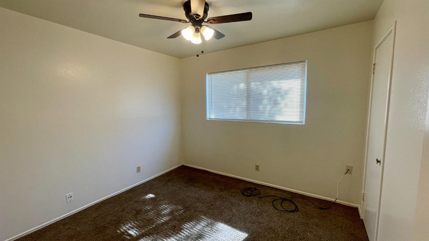 1412 Rodgers Road Hanford, CA 93230 - Photo 8 of 9 an empty room with a ceiling fan and a window