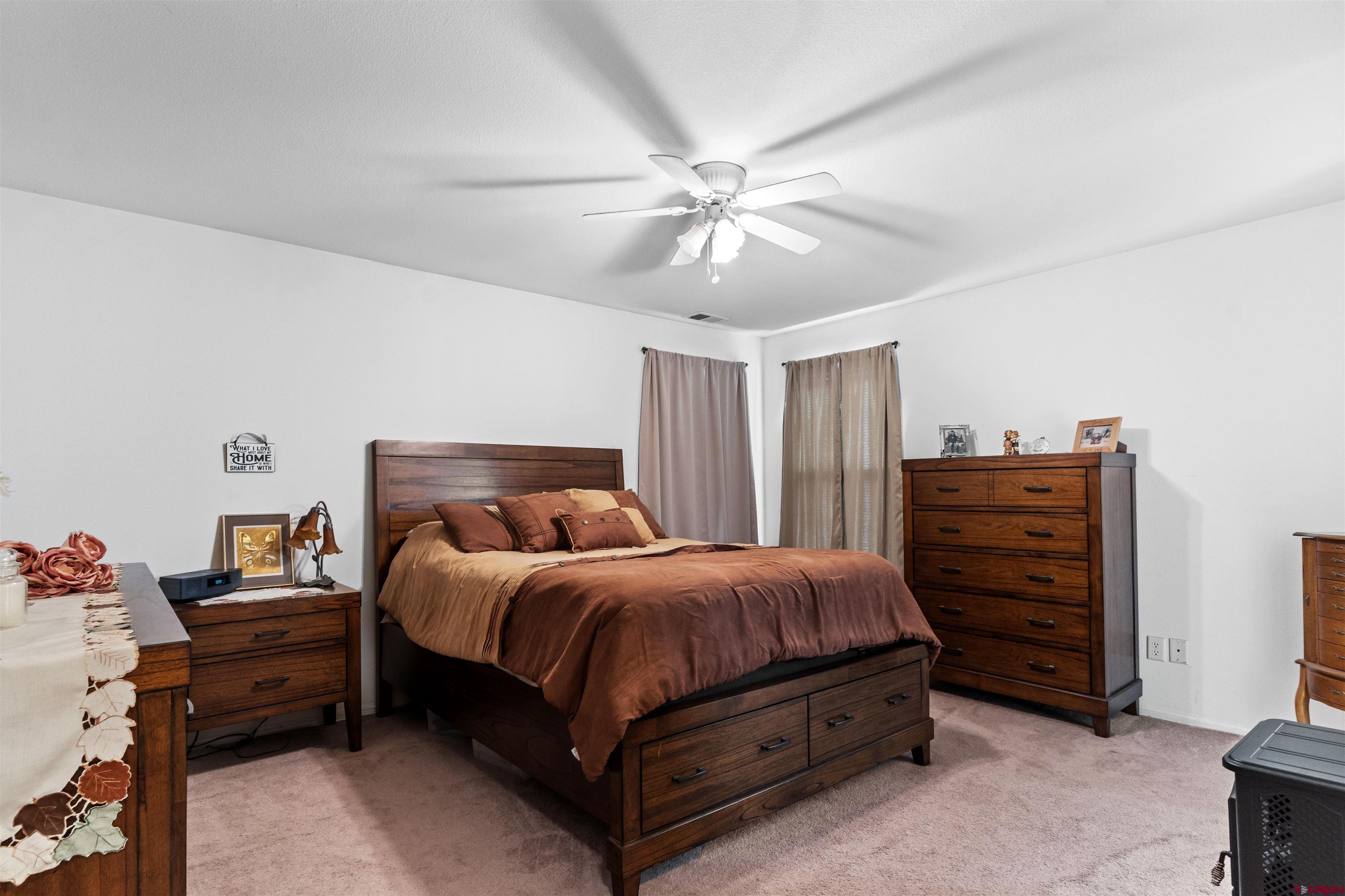 505 20th Street Delta, CO 81416 - Photo 11 of 22 a bedroom with a bed and a ceiling fan