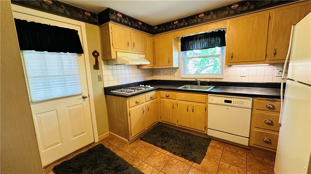 3218 Eastview Road Bethel Park, PA 15102 - Photo 20 of 49 Secure exit door to deck. Kitchen has white washed, maple cabinets, gas cooktop, electric built in oven, dishwasher, refrigerator, SS sink, under cabinet lighting, stainless steel sink, hooded fan and ceramic floor.