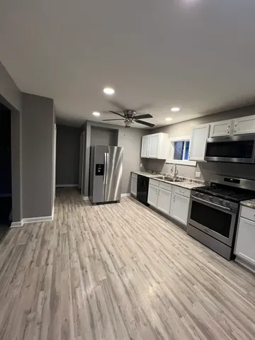 a kitchen with stainless steel appliances a refrigerator and a stove top oven