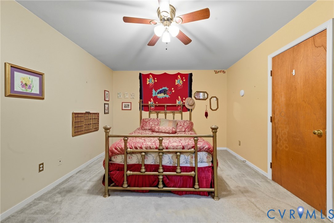 5606 Retriever Road Richmond, VA 23237 - Photo 16 of 27 a bedroom with a bed and a chandelier
