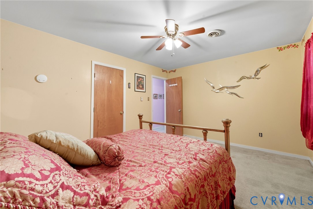 5606 Retriever Road Richmond, VA 23237 - Photo 17 of 27 a bedroom with a large bed and a chandelier