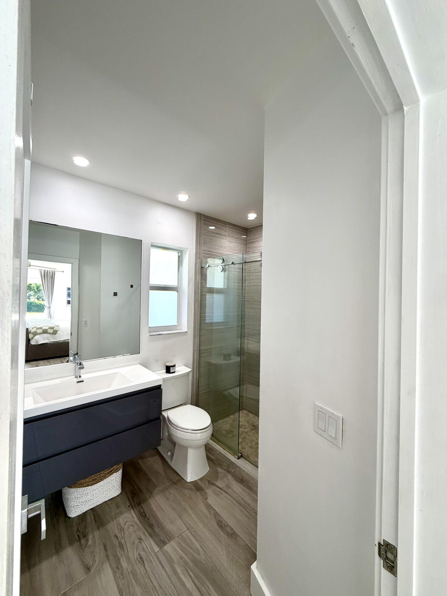 100 Southwest 11th Avenue Boca Raton, FL 33486 - Photo 11 of 34 a bathroom with a double vanity sink toilet a mirror and shower