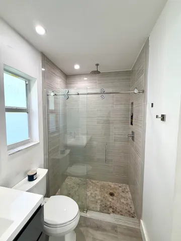 a bathroom with a shower a toilet and a sink