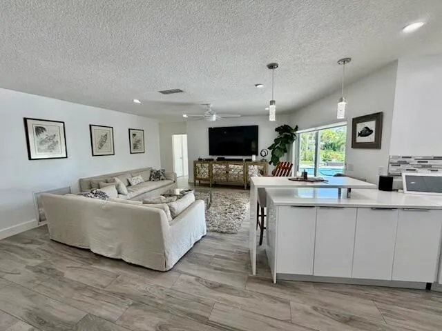 a living room with granite countertop furniture and a flat screen tv