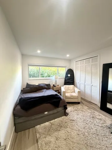 a bedroom with a bed and a large window