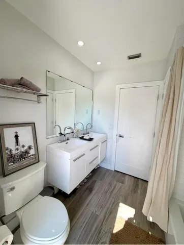 a bathroom with a sink mirror vanity and toilet