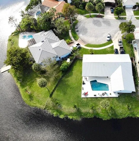 an aerial view of a house with a yard and lake view