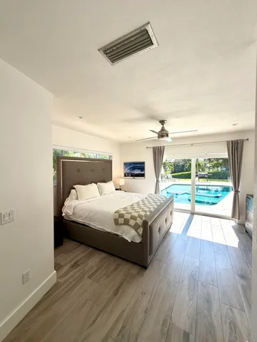 a spacious bedroom with a bed and wooden floor