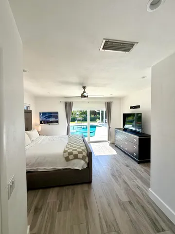 a bedroom with a bed a couch and a large window