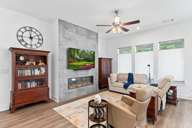 a living room with furniture a window and a flat screen tv