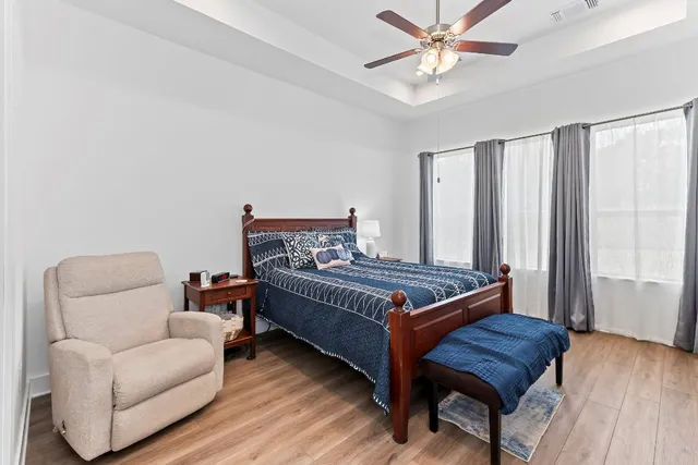 a bedroom with a bed and wooden floor