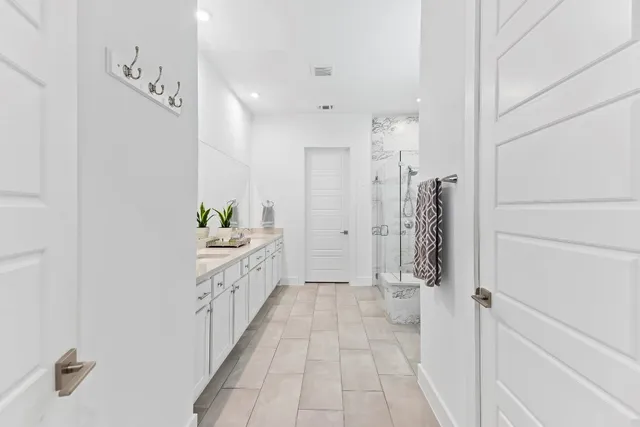 a bathroom with a double vanity sink and a shower