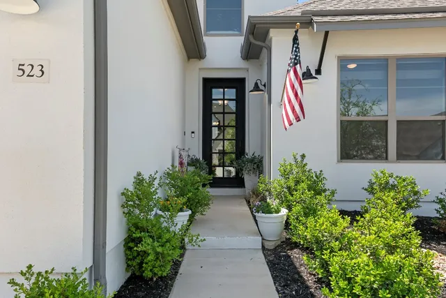 a view of yellow house with potted plants