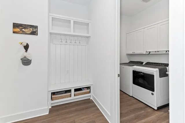 a view of kitchen with stainless steel appliances wooden floor and cabinets